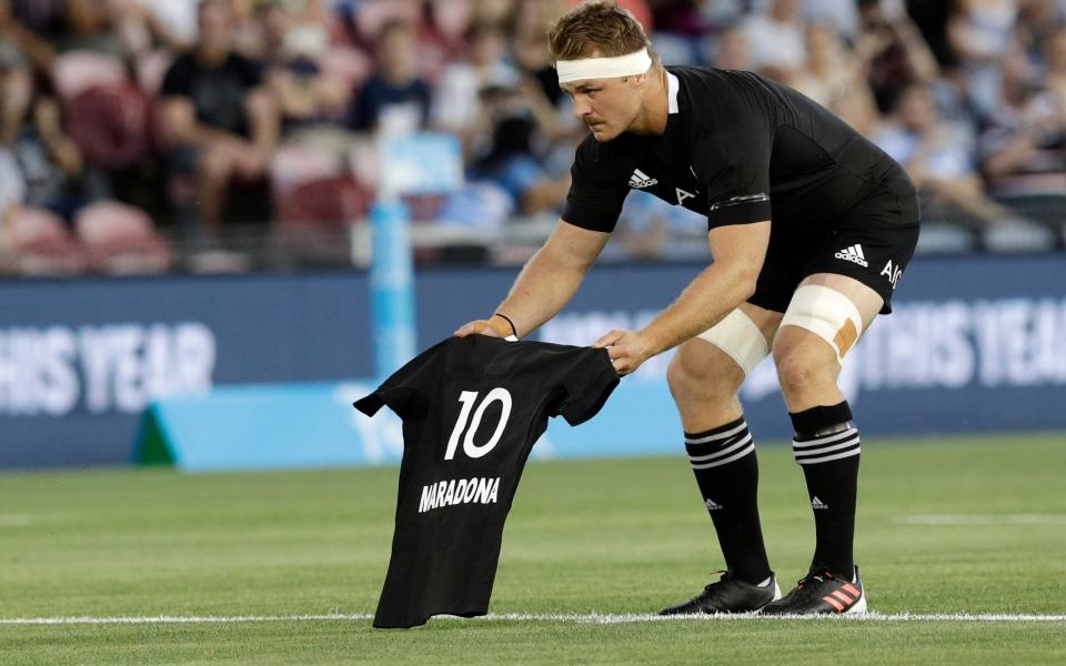 New Zealand captain Sam Cane lays an All Black No 10 jersey on the pitch in memory of Diego Maradona - AP