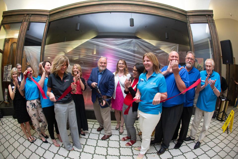 Members of the Jayhawk Theatre board and community leaders celebrate a June 8, 2021, ribbon cutting signifying the reopening of the historic theater in downtown Topeka.