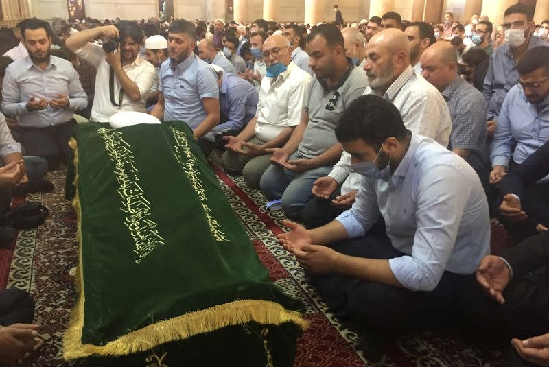 Relatives of Sunni Muslim Mufti Sheikh Mohammed Adnan Afiouni read the Quran during his funeral at Umayyad mosque in Damascus