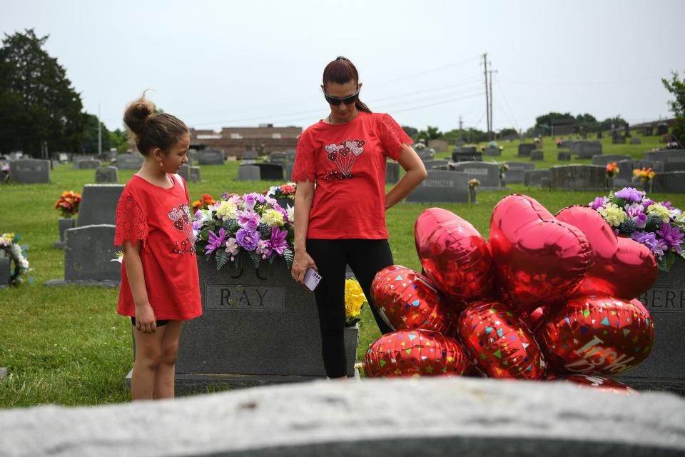 Jennifer Byrum stands next to her daughter, Brooklyn, at Strawberry Plains Cemetery ahead of a May 26 balloon release honoring her father, Ricky Lewis, who died after being held at Knox County’s Roger D. Wilson Detention Facility.