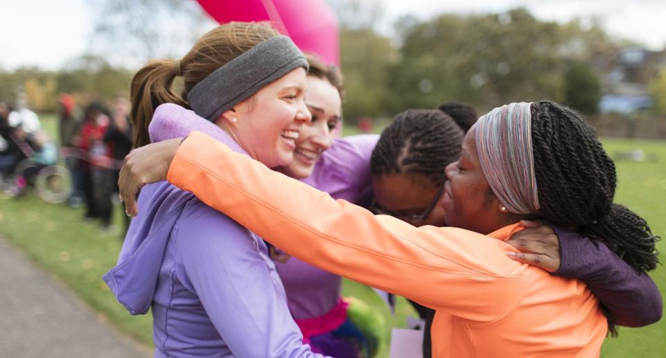 Group of friends hugging after running a marathon. (Getty Images)