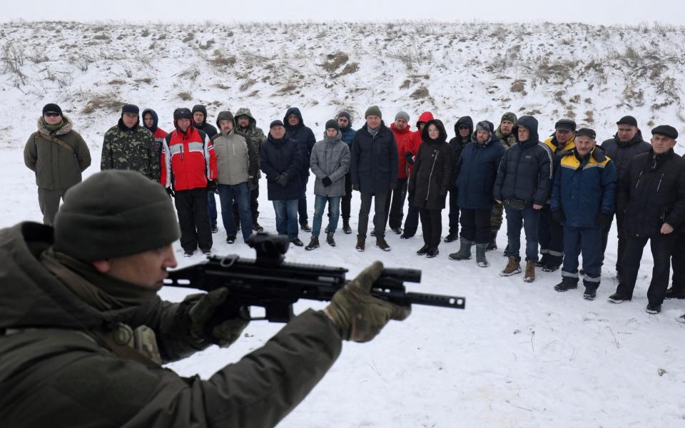 Employees of essential city industries and services attend a military training session outside Lviv - REUTERS/Roman Baluk