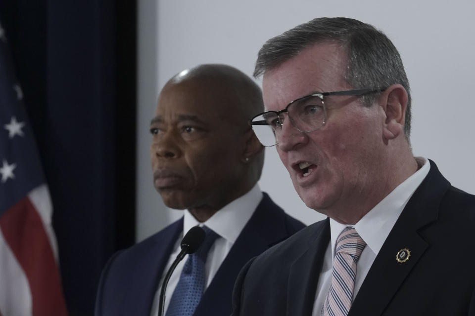 Mayor Eric Adams, left, listens as NYPD Chief of Detectives Joseph Kenny, right, speaks during a press conference where several charges for migrants involved in a Times Square brawl with police, Thursday, Feb. 8, 2024, in New York. (AP Photo/Bebeto Matthews)