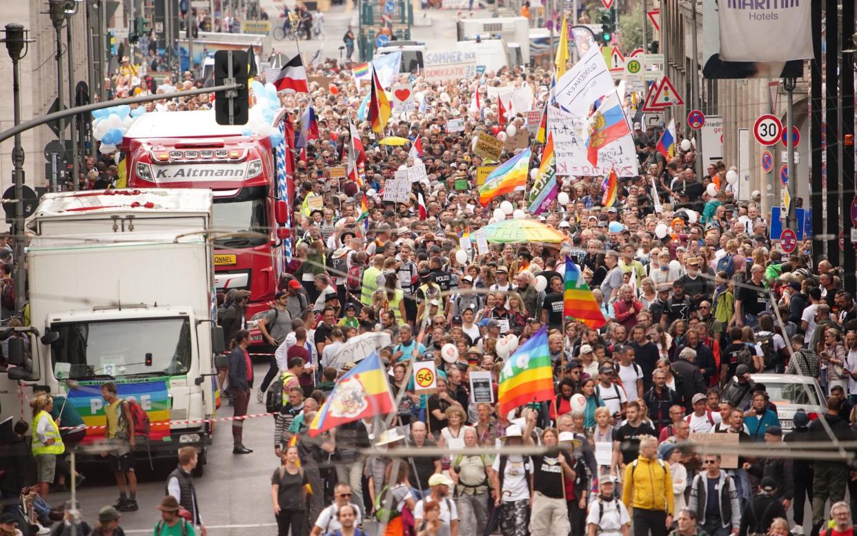 Demonstrators march during a protest against coronavirus pandemic regulations in Berlin, Germany - Shutterstock