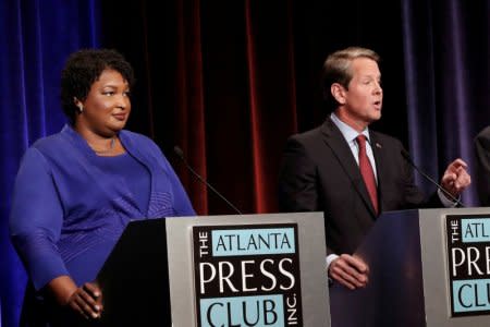 FILE PHOTO: Republican gubernatorial candidate for Georgia Brian Kemp speaks as Democratic candidate Stacey Abrams looks on during a debate in Atlanta, Georgia, U.S, October 23, 2018. John Bazemore/Pool via REUTERS/File Photo