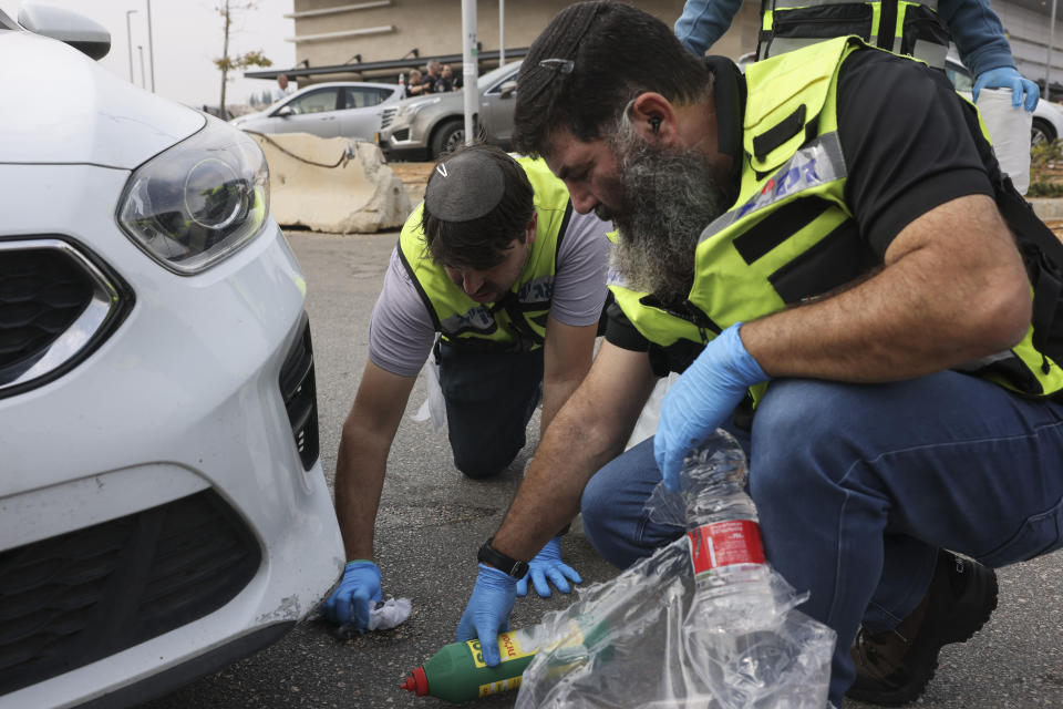 Members of Israeli Zaka Rescue and Recovery team clean blood from the site of an attack at the Ariel Industrial Zone near the West Bank Jewish settlement of Ariel, Tuesday, Nov. 15, 2022. A Palestinian killed two Israelis and wounded four others in an attack in a settlement in the occupied West Bank on Tuesday before he was shot and killed by Israeli security personnel, Israeli paramedics and Palestinian officials said. (AP Photo/Oren Ziv)