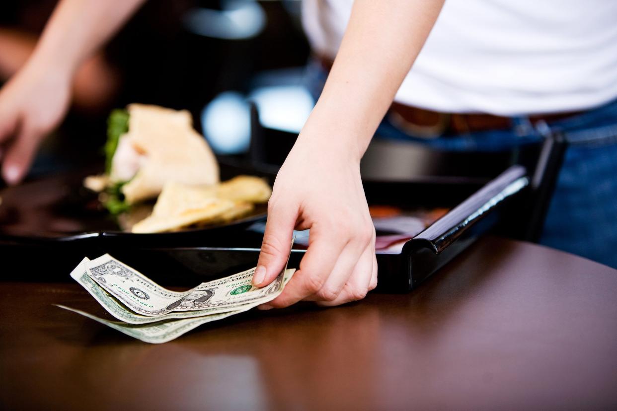 server picking up a cash tip