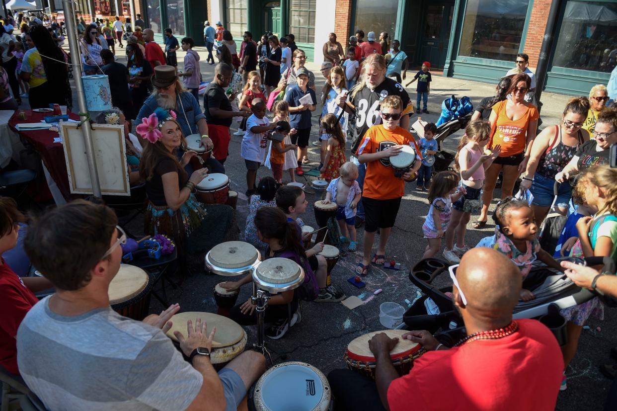 Kids play the bongos during Arts in the Heart on Saturday, Sept. 17, 2022. Attendees can eat food from around the world, browse for art, and watch live performances. The festival continues through Sunday. 