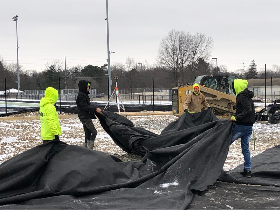 SCG Fields, which builds athletic fields, hired six Alliance High School seniors in the school's construction trades program to work for the company part-time and get hands-on experience. Pictured here, from left, are seniors Tyion Miles, Aiden Yacklin and Ke'sean Kilgore who are helping put cloth over a dirt surface on a baseball field.