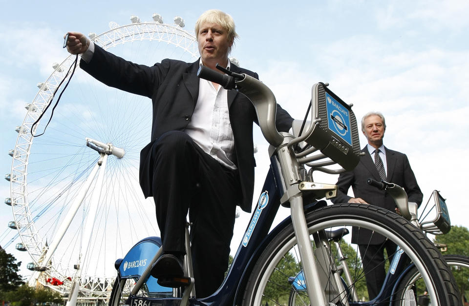 FILE - In this Friday, July 30, 2010 file photo, Boris Johnson, then Mayor of London, left, with the Chairman of Britain's Barclays Bank Marcus Agius as they poses for the media as a new cycle hire scheme starts in London. (AP Photo/Alastair Grant, File)