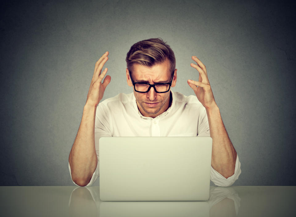 Stressed man working on computer. Negative human emotion face expression .