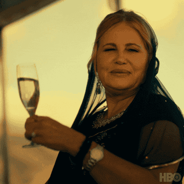 jennifer coolidge saying "wee hee" holdig a glass of champagne