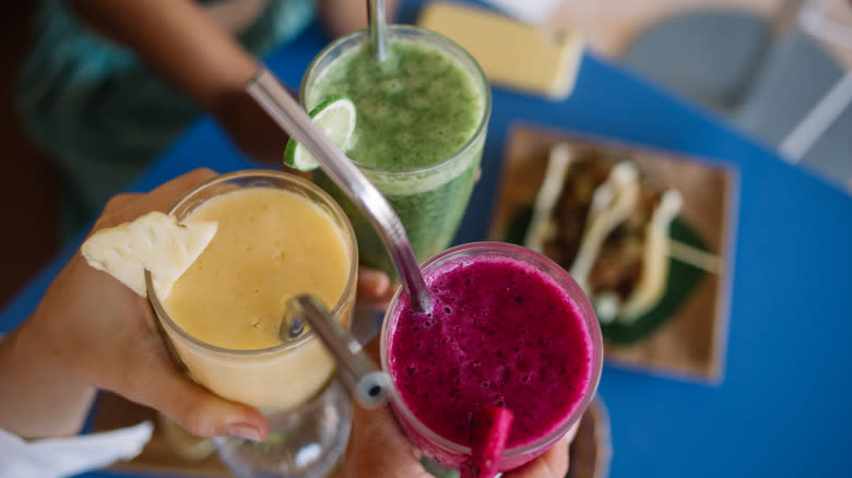 Three different smoothies in hands