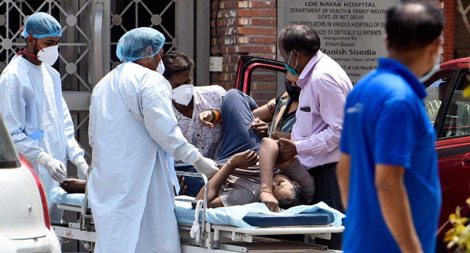 Health workers move a  Covid-19 patient at Lok Nayak Jai Prakash (LNJP) Hospital, this week in New Delhi. Source: Getty