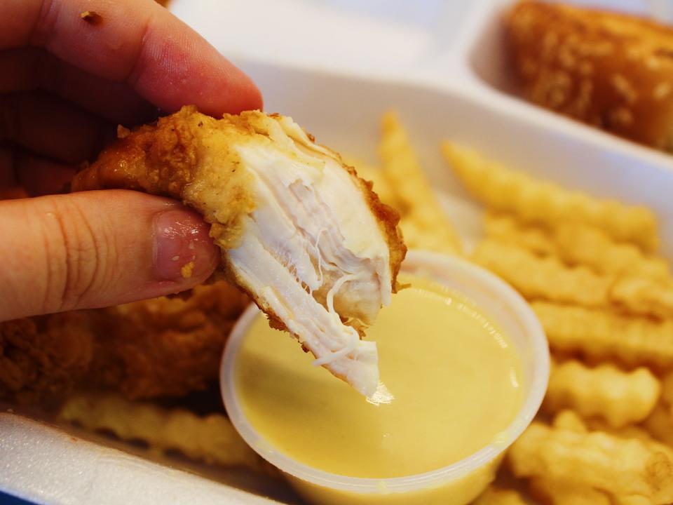 raising canes chicken tender dipped in honey mustard