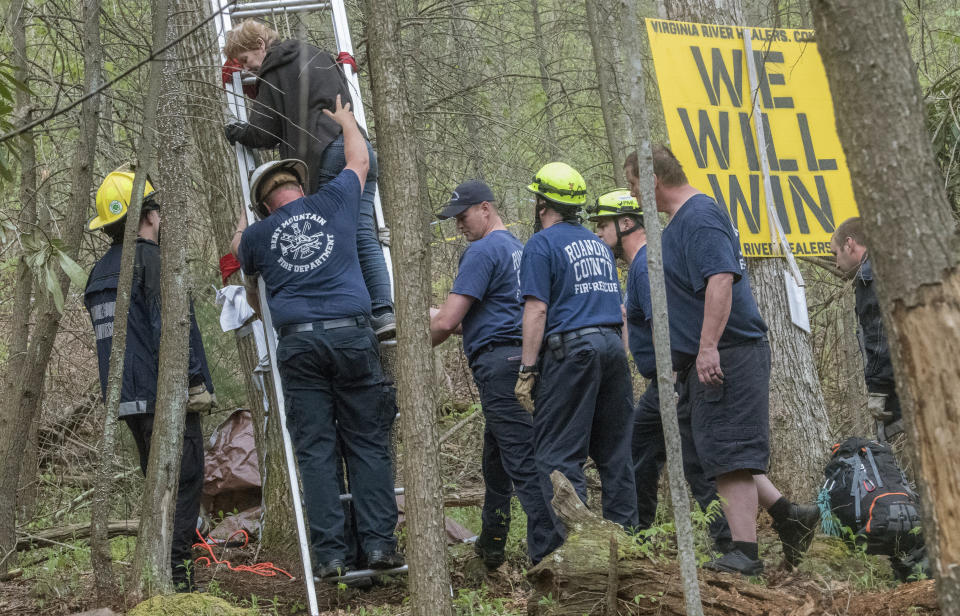FILE - Protester, Theresa Minor Terry, top, leaves the tree stand she has occupied for the past five weeks along the Mountain Valley Pipeline route on Saturday, May 5, 2018, on Bent Mountain, Va., where she and her daughter have been protesting a natural gas pipeline granted eminent domain to run through their property, after a federal judge found her in contempt of a court order. The U.S. Forest Service has reissued approval for a controversial and long-delayed natural gas pipeline to run through Jefferson National Forest in Virginia and West Virginia. (Don Petersen/Roanoke Times via AP, File)