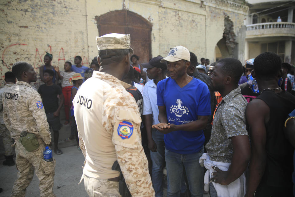 Police officers block a group of persons as they protest against the arrival of the USNS Comfort hospital ship in Jeremie, Haiti, Tuesday, Dec. 13, 2022. The USNS Comfort is on a humanitarian mission to provide dental and medical services. (AP Photo/Odelyn Joseph)