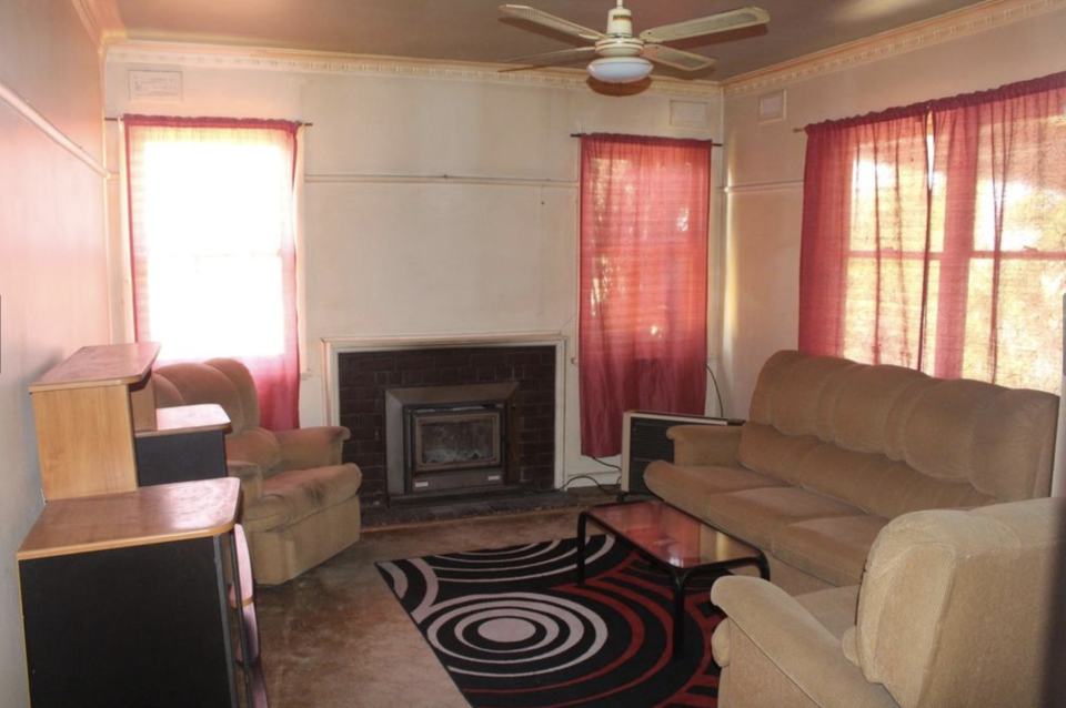 The Servicton home's living room with red curtains and carpet. 