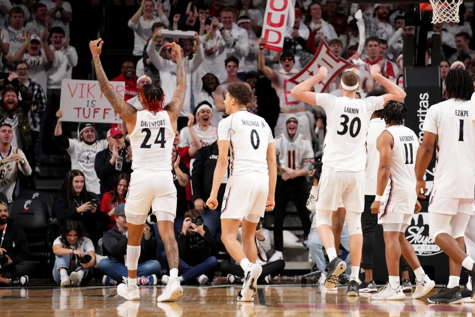 Cincinnati Bearcats guard Jeremiah Davenport (24), Cincinnati Bearcats guard Dan Skillings Jr. (0) and Cincinnati Bearcats forward Viktor Lakhin (30) celebrate a dunk in their 73-64 win over UCF Saturday.