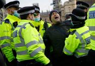 Police officers detain a protestor during an anti-COVID-19 lockdown demonstration outside the Houses of Parliament in Westminster, central London on January 6, 2021. - Britain toughened its coronavirus restrictions on Tuesday, with England and Scotland going into lockdown and shutting schools, as surging cases have added to fears of a new virus variant. (Photo by Tolga Akmen / AFP) (Photo by TOLGA AKMEN/AFP via Getty Images)