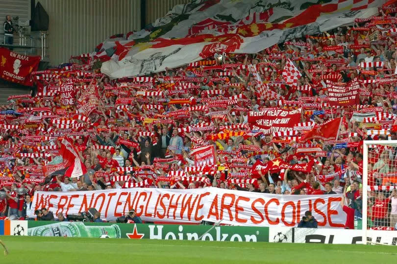 Liverpool fans on the Kop hold a banner reading 'We're not English We Are Scouse'