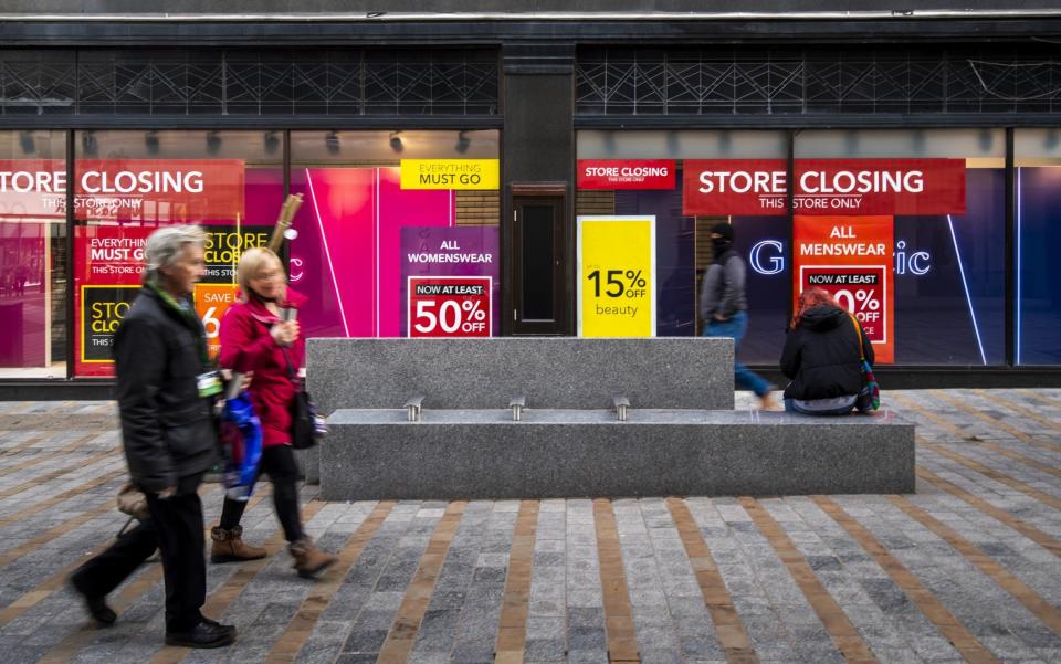 Pedestrians walk past a store advertising a closing down sale in Leeds - Anthony Devlin/ Bloomberg