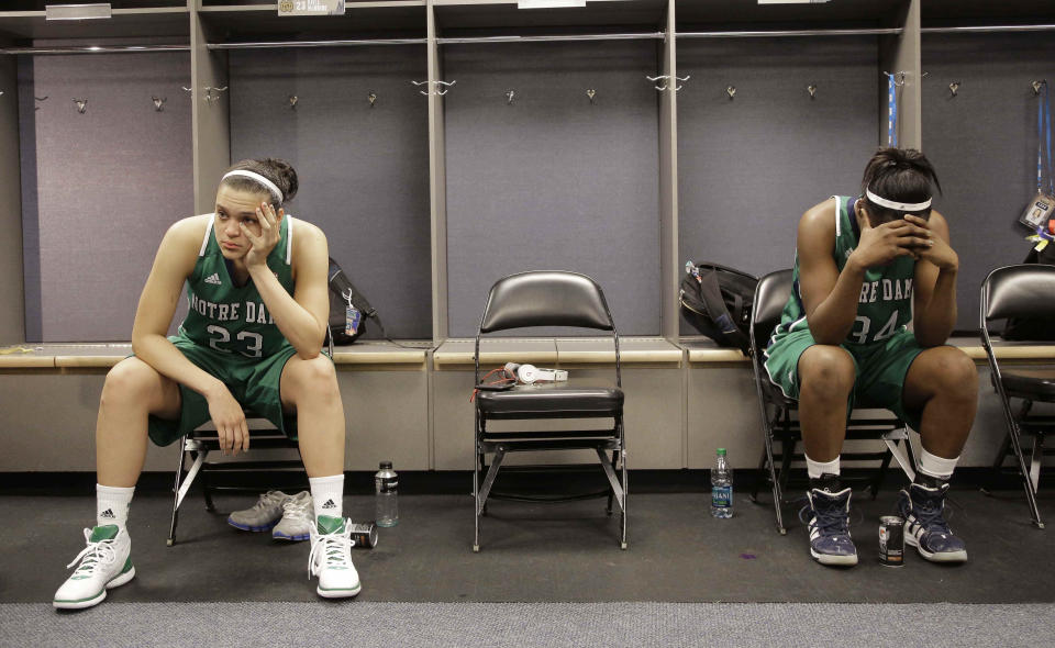 FILE - Notre Dame guard Kayla McBride (23) and Notre Dame forward Markisha Wright (34) sit in the locker room after the NCAA Women's Final Four college basketball championship game against Baylor in Denver, Tuesday, April 3, 2012. Baylor won 80-61.(AP Photo/Julie Jacobson, File)
