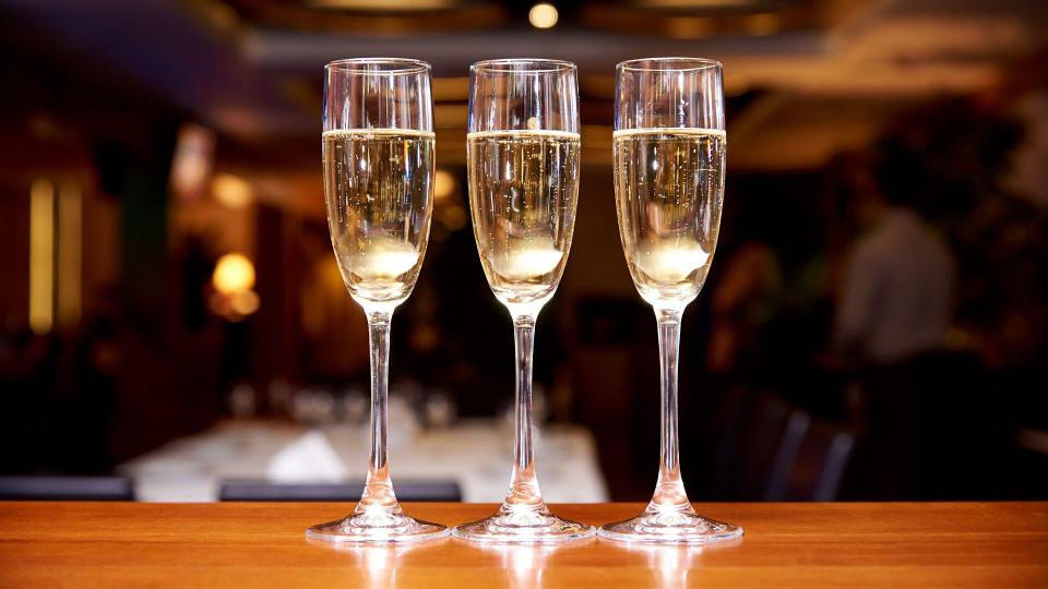 Glasses with champagne on the bar counter in a restaurant against a dark background.