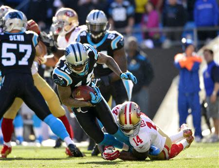 Jan 12, 2014; Charlotte, NC, USA; Carolina Panthers wide receiver Ted Ginn (19) is brought down by San Francisco 49ers wide receiver Kassim Osgood (14) during the third quarter of the 2013 NFC divisional playoff football game at Bank of America Stadium. Bob Donnan-USA TODAY Sports