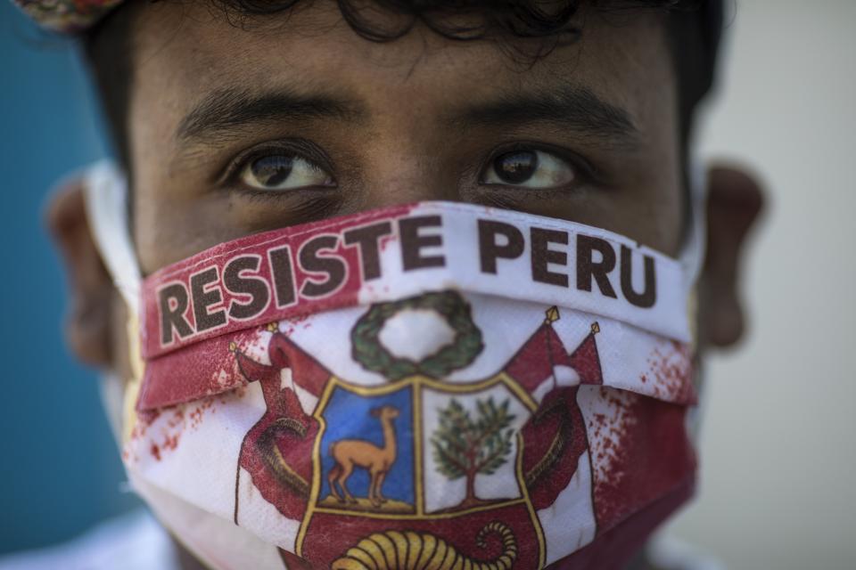 John Sanchez wears a face mask with the Spanish message "Resist Peru" as he waits in line to be tested for COVID-19 at Almenara Hospital in Lima, Peru, Friday, April 24, 2020. (AP Photo/Rodrigo Abd)