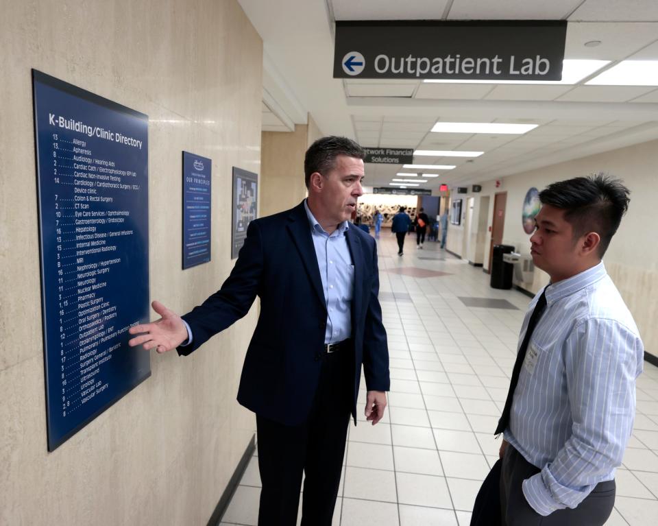 Scott Ragland, the director of vendor contracting and centralized staffing for Henry Ford Health, left, talks with Jerick Tabudlo about the various levels and departments in the massive Henry Ford Hospital in Detroit on Thursday, April 27, 2023. Tabudlo is an operating room nurse from the Philippines and landed in Detroit on Tuesday, April 25 to start a new job at the hospital. With a big nurse shortage going on, Henry Ford Health looked toward the Philippines and Tabudlo is the first of as many as 600 who are expected to come in the next year to fill various open nursing positions throughout the health system.