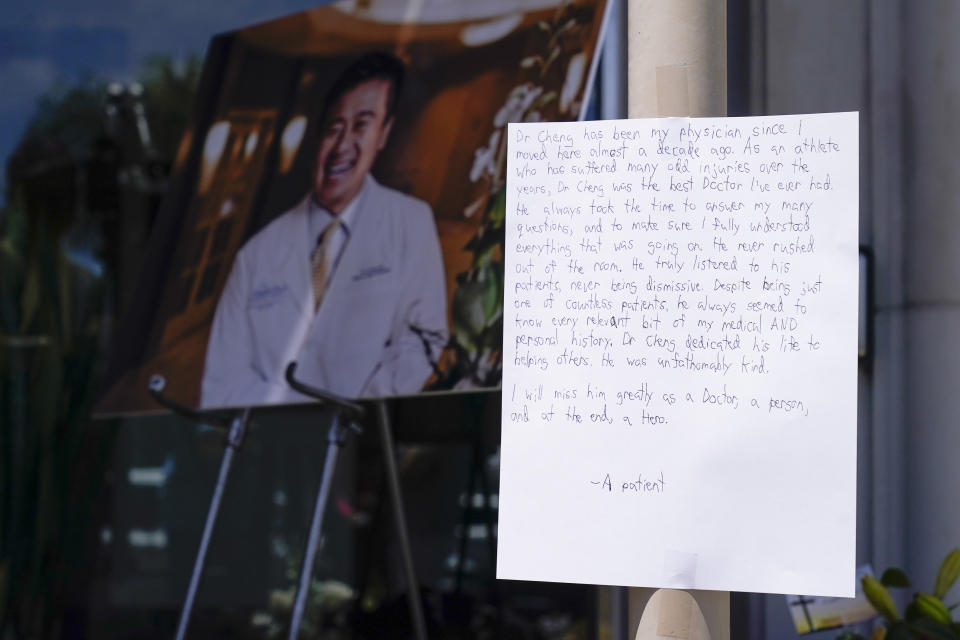 A note from a patient is left at a memorial honoring Dr. John Cheng outside his office building on Tuesday, May 17, 2022, in Aliso Viejo, Calif. Cheng, 52, was killed in Sunday's shooting at Geneva Presbyterian Church. (AP Photo/Ashley Landis)