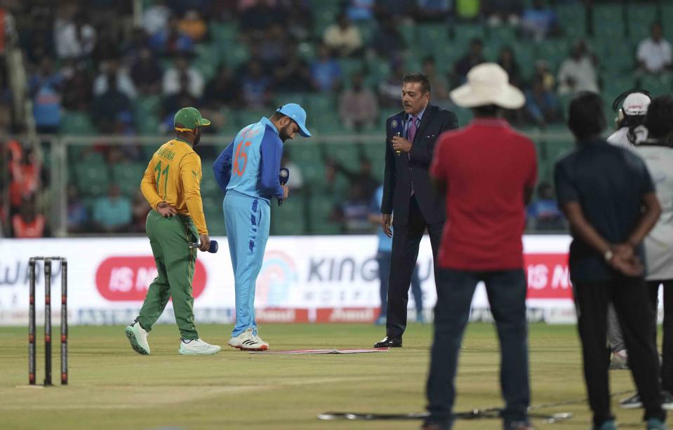 Indian cricketer Captain Rohit Sharma, in blue, and South Africa's Captain Temba Bavuma watch the toss of coin before the start of the first Twenty20 cricket match against South Africa in Thiruvananthapuram, India, Wednesday, Sept. 28, 2022. (AP Photo/Mahesh Kumar A.)