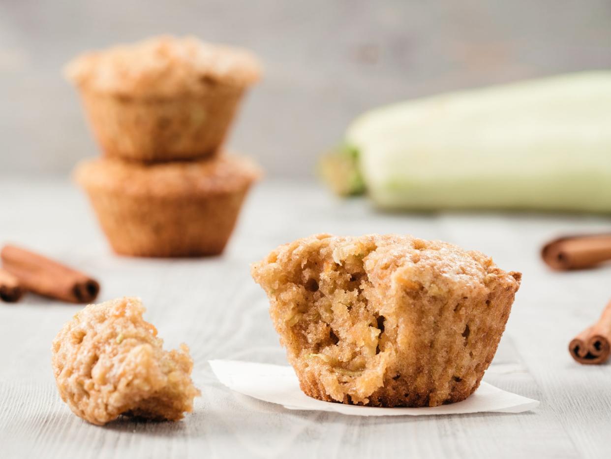 Close up view of muffin with zucchini, carrots, apple and cinnamon on gray wooden background. Sweet vegetables homemade muffins. Toddler-friendly recipe idea. Copy space. Shallow DOF