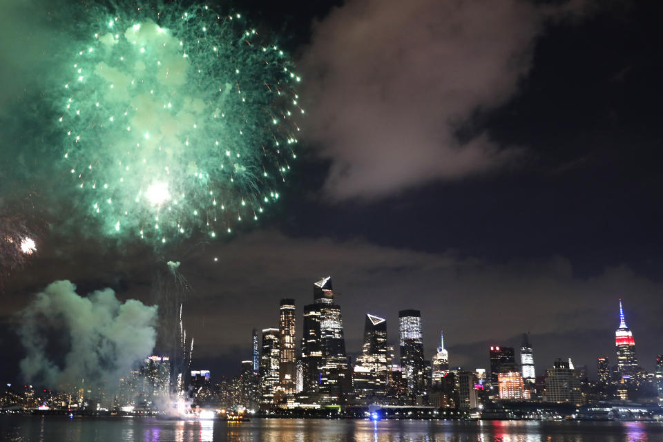 A surprise display of fireworks sponsored by Macy's explode over the Hudson Yards area of Manhattan as seen from a pier in Hoboken, N.J., late Tuesday, June 30, 2020. The fireworks were not announced until an hour or so before to avoid attracting large crowds. (AP Photo/Kathy Willens)