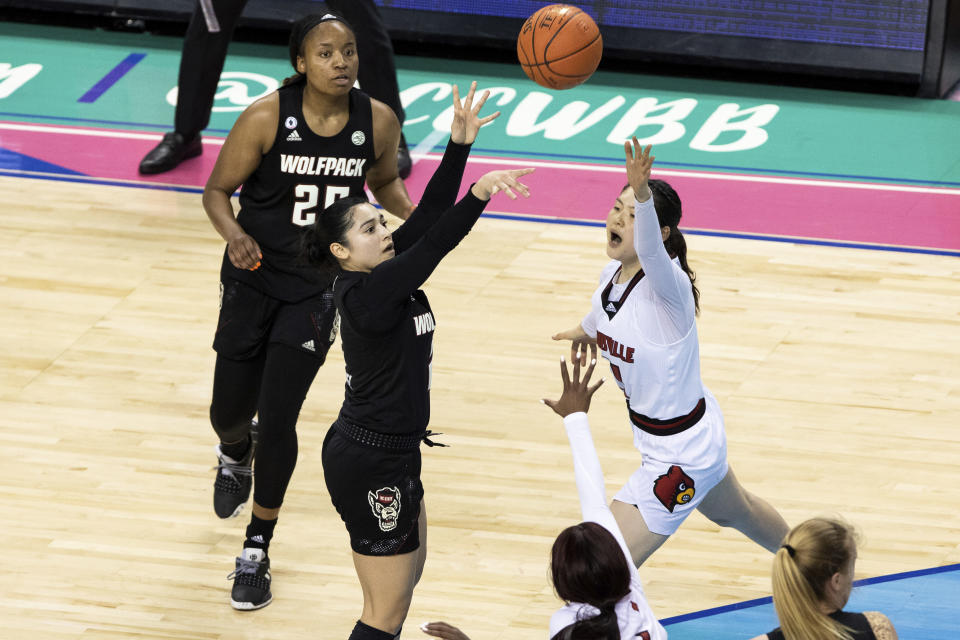 North Carolina State's Raina Perez (2) scores the game-winning basket over Louisville's Norika Konno (11) during the the championship of Atlantic Coast Conference NCAA women's college basketball game in Greensboro, N.C., Sunday, March 7, 2021. (AP Photo/Ben McKeown)