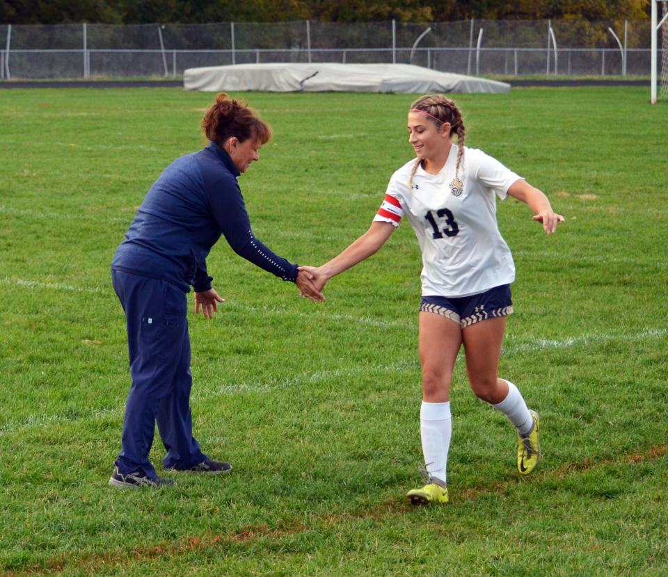 St. Maria Goretti's Mollie Rebuck (13) slaps five with Gaels coach Terri Mutchler during player introductions at Smithsburg on Oct. 17, 2022. Rebuck scored two goals in the game.