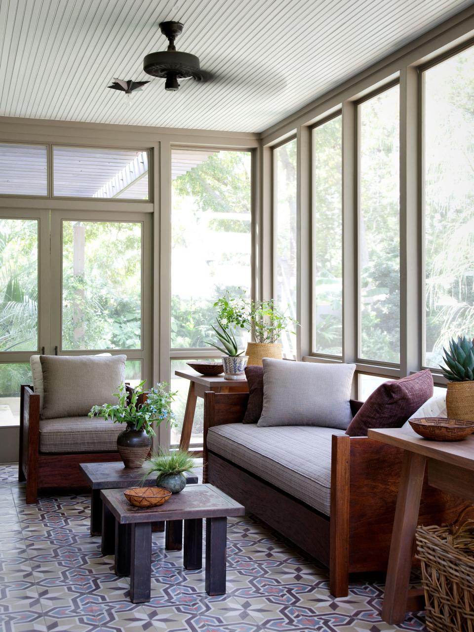 Moroccan cement tiles line the floor of the screened porch. Steel tables by Blend Interiors.