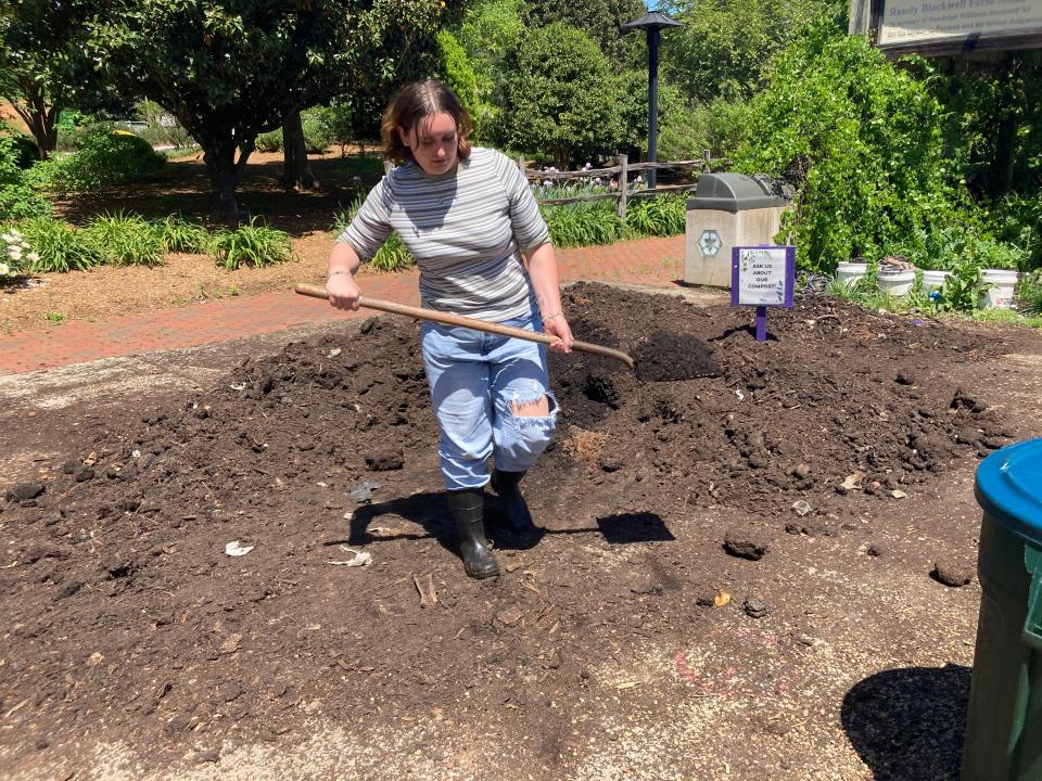 Farm assistant Cai Richlowski, a freshman at Furman University, works on the compost pile near Furman Farm.