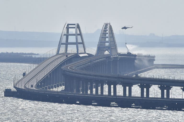 Un helicóptero deja caer agua para detener un incendio en el Puente de Crimea que conecta a Rusia con la península de Crimea, el 8 de octubre de 2022, en Kerch. (AP Foto, Archivo)