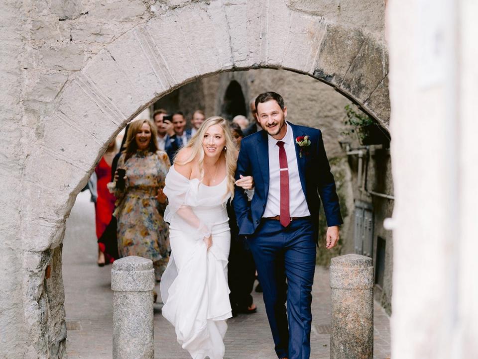 A couple walking under a bridge.