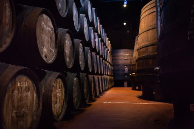 <p>Maksim Ozerov / Getty Images</p> Port wine barrels maturing in a warehouse of Porto Calem, on the banks of Douro river