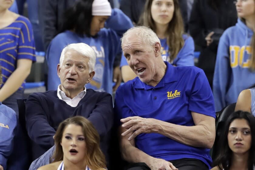 Former UCLA basketball player Bill Walton, right, talks to UCLA Chancellor Gene Block at a basketball game