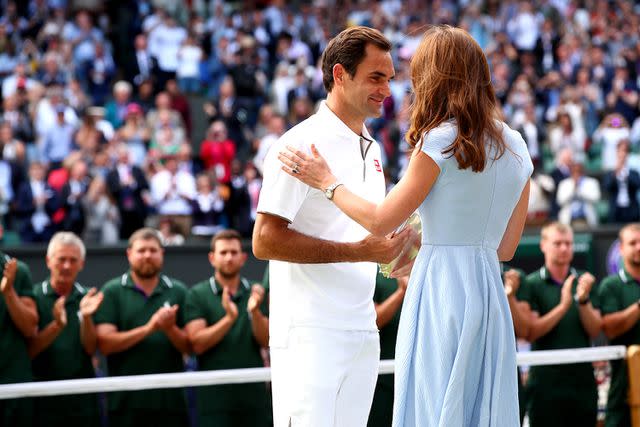 <p>Clive Brunskill/Getty Images</p> Kate Middleton presents Roger Federer with the runner-up trophy for the men's singles final at Wimbledon in July 2019.