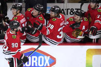 Chicago Blackhawks center Tyler Johnson (90) celebrates with teammates after scoring a goal against the Detroit Red Wings during the first period of an NHL hockey game in Chicago, Sunday, Oct. 24, 2021. (AP Photo/Nam Y. Huh)