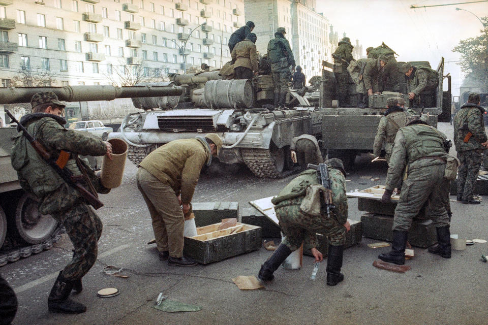 FILE - Russian army soldiers unload boxes with shells and carry them to tanks for an attack on the Russian parliament building in Moscow on Oct. 4, 1993. The October 1993 violent showdown between the Kremlin and supporters of the rebellious parliament marked a watershed in Russia's post-Soviet history. (AP Photo/Vladimir Svartsevich, File)