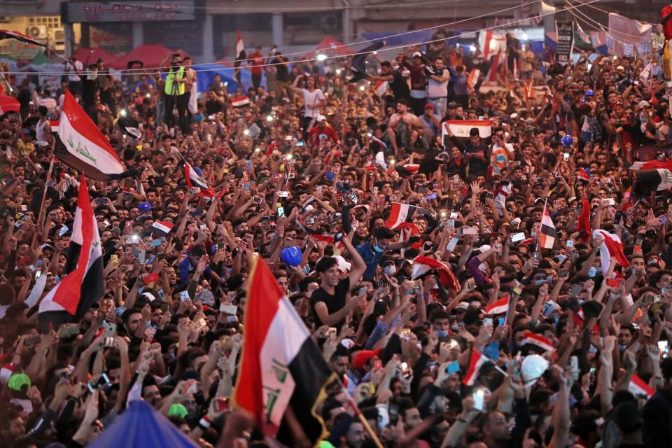 Anti-government protesters celebrate a soccer match win in Tahrir Square in Baghdad, Iraq, Thursday, Nov. 14, 2019. Iraqis are celebrating a 2-1 win over Iran in a much-anticipated World Cup qualifying match. (AP Photo/Hadi Mizban)