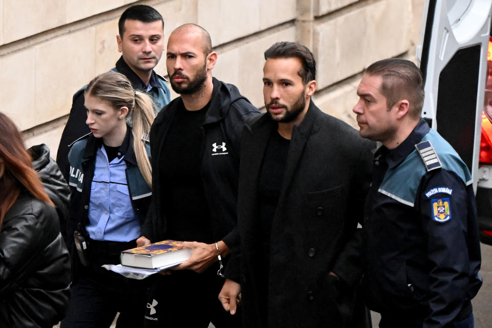 andrew tate and brother being escorted into court