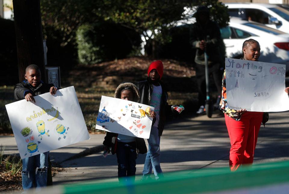 Kids hold up signs along the parade route during the annual Martin Luther King, Jr. Day Parade on Monday January 16, 2023. 