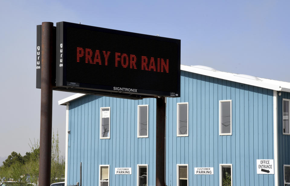 An electronic sign outside a business in Las Vegas, New Mexico, on Wednesday, May 4, 2022, asks passersby to "Pray for Rain" as a massive wildfire spreads in the nearby mountains. Many New Mexico families are deep-rooted not only in the land but in their faith. As the largest wildfire burning in the U.S. marches across the high alpine forests and grasslands of the Sangre de Cristo Mountains, they've pleaded with God for intervention in the form of rain and calm winds, and protection for their neighbors and beloved landscape. (AP Photo/Thomas Peipert)